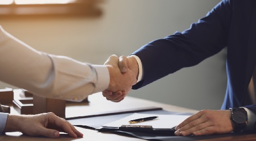 people shaking hands over document